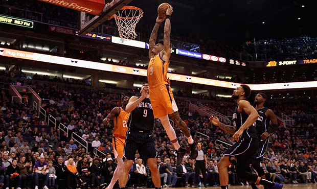 Kelly Oubre Jr. #3 of the Phoenix Suns slam dunks the ball over Nikola Vucevic #9 of the Orlando Ma...