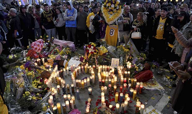 People gather at a memorial near Staples Center after the death of Laker legend Kobe Bryant Sunday,...