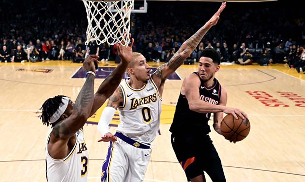 Phoenix Suns' Devin Booker (1) looks to pass the ball under pressure from Los Angeles Lakers' Kyle ...