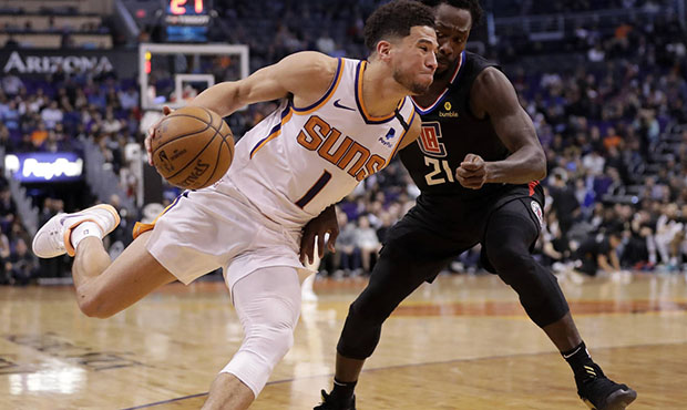 Phoenix Suns guard Devin Booker (1) drives past Los Angeles Clippers guard Patrick Beverley (21) du...