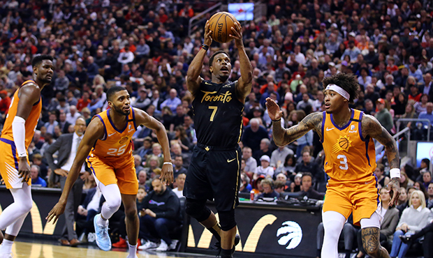 Kyle Lowry #7 of the Toronto Raptors shoots the ball as Kelly Oubre Jr. #3 of the Phoenix Suns defe...