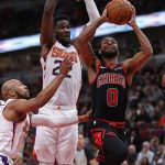 CHICAGO, ILLINOIS - FEBRUARY 22: Coby White #0 of the Chicago Bulls puts up a shot against Ricky Rubio #11 (L) and Deandre Ayton #22 of the Phoenix Suns at the United Center on February 22, 2020 in Chicago, Illinois. NOTE TO USER: User expressly acknowledges and agrees that, by downloading and or using this photograph, User is consenting to the terms and conditions of the Getty Images License Agreement. (Photo by Jonathan Daniel/Getty Images)