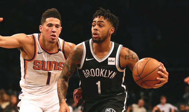 D'Angelo Russell #1 of the Brooklyn Nets dribbles against Devin Booker #1 of the Phoenix Suns durin...