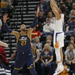 Phoenix Suns guard Devin Booker (1) shoots as Utah Jazz center Rudy Gobert (27) defends in the first half during an NBA basketball game Monday, Feb. 24, 2020, in Salt Lake City. (AP Photo/Rick Bowmer)