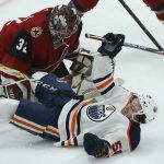 Edmonton Oilers right wing Kailer Yamamoto, right, is pulled down in front of Arizona Coyotes goaltender Antti Raanta (32) during the first period of an NHL hockey game Tuesday, Feb. 4, 2020, in Glendale, Ariz. (AP Photo/Ross D. Franklin)