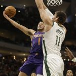 Phoenix Suns' Devin Booker, front left, drives against Milwaukee Bucks' Brook Lopez during the second half of an NBA basketball game Sunday, Feb. 2, 2020, in Milwaukee. (AP Photo/Jeffrey Phelps)