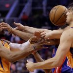Phoenix Suns guard Jevon Carter, left, forward Dario Saric, right, battle with Detroit Pistons guard Brandon Knight for the loose ball during the first half of an NBA game, Friday, Feb. 28, 2020, in Phoenix. (AP Photo/Matt York)