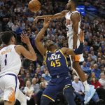 Utah Jazz guard Donovan Mitchell (45) loses the ball after being fouled by Phoenix Suns guard Devin Booker (1) while driving to the basket in the first half during an NBA basketball game Monday, Feb. 24, 2020, in Salt Lake City. (AP Photo/Rick Bowmer)
