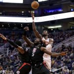 Phoenix Suns center Deandre Ayton, right, rebounds over Los Angeles Clippers forward Montrezl Harrell (5) during the second half of an NBA basketball game, Wednesday, Feb. 26, 2020, in Phoenix. The Clippers won 102-92. (AP Photo/Matt York)