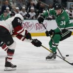 Arizona Coyotes defenseman Alex Goligoski (33) and Dallas Stars right wing Denis Gurianov (34) reach for the puck during the first period of an NHL hockey game in Dallas, Wednesday, Feb. 19, 2019. (AP Photo/Michael Ainsworth)
