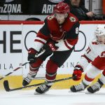 Arizona Coyotes center Nick Schmaltz (8) tries to keep the puck away from Carolina Hurricanes center Lucas Wallmark (71) during the third period of an NHL hockey game Thursday, Feb. 6, 2020, in Glendale, Ariz. The Hurricanes won 5-3. (AP Photo/Ross D. Franklin)