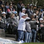 People cheer on the 15th tee of the Pebble Beach Golf Links as Josh Duhamel and Tony Romo prepare to hit during the third round of the AT&T Pebble Beach National Pro-Am golf tournament Saturday, Feb. 8, 2020, in Pebble Beach, Calif. (AP Photo/Eric Risberg)