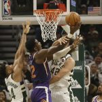 Phoenix Suns' Deandre Ayton (22) shoots against Giannis Antetokounmpo, left, and Robin Lopez during the first half of an NBA basketball game Sunday, Feb. 2, 2020, in Milwaukee. (AP Photo/Jeffrey Phelps)