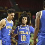 With his team down by double digits to Arizona State, UCLA's Tyger Campbell (10) gathers his teammates Chris Smith, left, Jules Bernard (3) and Cody Riley (2) during the second half of an NCAA college basketball game, Thursday, Feb. 6, 2020, in Tempe, Ariz. (AP Photo/Darryl Webb)
