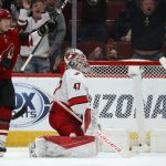 Arizona Coyotes center Christian Dvorak (18) celebrates a goal by Conor Garland as Carolina Hurricanes goaltender James Reimer (47) kneels on the ice during the third period of an NHL hockey game Thursday, Feb. 6, 2020, in Glendale, Ariz. The Hurricanes won 5-3. (AP Photo/Ross D. Franklin)