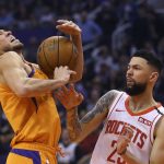 Phoenix Suns guard Devin Booker, left, is fouled by Houston Rockets guard Austin Rivers, right, during the second half of an NBA basketball game Friday, Feb. 7, 2020, in Phoenix. (AP Photo/Ross D. Franklin)