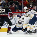 Arizona Coyotes defenseman Jordan Oesterle (82) scores a goal as he gets the puck past Buffalo Sabres goaltender Jonas Johansson (34), defenseman Colin Miller (33) and left wing Jeff Skinner (53) during the second period of an NHL hockey game Saturday, Feb. 29, 2020, in Glendale, Ariz. (AP Photo/Ross D. Franklin)