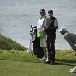 Dustin Johnson, right, helps Wayne Gretzky, center, line up his shot to the ninth green of the Pebble Beach Golf Links during the third round of the AT&T Pebble Beach National Pro-Am golf tournament Saturday, Feb. 8, 2020, in Pebble Beach, Calif. (AP Photo/Eric Risberg)
