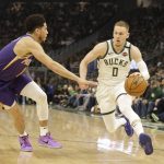 Milwaukee Bucks' Donte DiVincenzo(0) drives against the Phoenix Suns' Devin Booker during the first half of an NBA basketball game Sunday, Feb. 2, 2020, in Milwaukee. (AP Photo/Jeffrey Phelps)