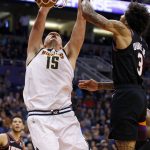 Denver Nuggets center Nikola Jokic (15) dunks next to Phoenix Suns forward Kelly Oubre Jr. (3) during the second half of an NBA basketball game Saturday, Feb. 8, 2020, in Phoenix. (AP Photo/Ralph Freso)