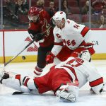 Carolina Hurricanes goaltender James Reimer, right, makes a save on a shot by Arizona Coyotes right wing Conor Garland (83) as Hurricanes right wing Justin Williams (14) defends during the second period of an NHL hockey game Thursday, Feb. 6, 2020, in Glendale, Ariz. (AP Photo/Ross D. Franklin)