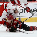 Carolina Hurricanes defenseman Joel Edmundson (6) sends Arizona Coyotes left wing Taylor Hall (91) to the ice during the second period of an NHL hockey game Thursday, Feb. 6, 2020, in Glendale, Ariz. (AP Photo/Ross D. Franklin)