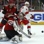 Arizona Coyotes goaltender Antti Raanta (32) makes a save on a shot as defenseman Niklas Hjalmarsson (4) and Carolina Hurricanes left wing Teuvo Teravainen (86) watch during the first period of an NHL hockey game Thursday, Feb. 6, 2020, in Glendale, Ariz. (AP Photo/Ross D. Franklin)