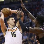 Denver Nuggets center Nikola Jokic (15) looks to shoot as Phoenix Suns center Deandre Ayton (22) defends during the first half of an NBA basketball game, Saturday, Feb. 8, 2020, in Phoenix. (AP Photo/Ralph Freso)
