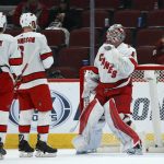 Carolina Hurricanes goaltender James Reimer, right, celebrates the team's win over the Arizona Coyotes with defensemen Haydn Fleury (4) and Joel Edmundson (6), at the end of the NHL hockey game Thursday, Feb. 6, 2020, in Glendale, Ariz. The Hurricanes won 5-3. (AP Photo/Ross D. Franklin)