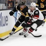 Arizona Coyotes' Christian Dvorak (18) battles for the puck with Boston Bruins' John Moore during the second period of an NHL hockey game Saturday, Feb. 8, 2020, in Boston. (AP Photo/Winslow Townson)