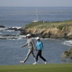 Dustin Johnson, left, and Jordan Spieth walk down the ninth fairway of the Pebble Beach Golf Links during the third round of the AT&T Pebble Beach National Pro-Am golf tournament Saturday, Feb. 8, 2020, in Pebble Beach, Calif. (AP Photo/Eric Risberg)
