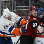 New York Islanders defenseman Scott Mayfield (24) checks Arizona Coyotes right wing Conor Garland (83) in the second period during an NHL hockey game, Monday, Feb. 17, 2020, in Glendale, Ariz. (AP Photo/Rick Scuteri)