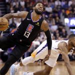 Los Angeles Clippers guard Paul George (13) is fouled by Phoenix Suns forward Mikal Bridges during the first half of an NBA basketball game, Wednesday, Feb. 26, 2020, in Phoenix. (AP Photo/Matt York)