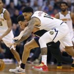 Denver Nuggets guard Gary Harris (14) and Phoenix Suns guard Devin Booker battle to gain control of the ball during the second half of an NBA basketball game, Saturday, Feb. 8, 2020, in Phoenix. (AP Photo/Ralph Freso)