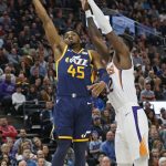 Utah Jazz guard Donovan Mitchell (45) lays up the ball as Phoenix Suns center Deandre Ayton (22) defends in the first half during an NBA basketball game Monday, Feb. 24, 2020, in Salt Lake City. (AP Photo/Rick Bowmer)