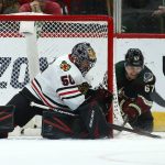 Chicago Blackhawks goaltender Corey Crawford (50) makes a save on a shot from Arizona Coyotes left wing Lawson Crouse (67) during the first period of an NHL hockey game Saturday, Feb. 1, 2020, in Glendale, Ariz. (AP Photo/Ross D. Franklin)