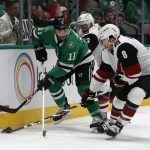 Dallas Stars center Andrew Cogliano (11) and Arizona Coyotes defenseman Alex Goligoski (33) and center Nick Schmaltz (8) work along the boards during the first period of an NHL hockey game in Dallas, Wednesday, Feb. 19, 2019. (AP Photo/Michael Ainsworth)