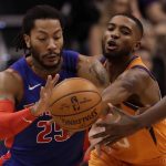 Detroit Pistons guard Derrick Rose (25) chases down a lose ball with Phoenix Suns forward Mikal Bridges during the second half of an NBA game, Friday, Feb. 28, 2020, in Phoenix. (AP Photo/Matt York)