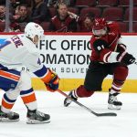 Arizona Coyotes left wing Taylor Hall (91) shoots in fornt of New York Islanders defenseman Andy Greene (4) in the second period during an NHL hockey game, Monday, Feb. 17, 2020, in Glendale, Ariz. (AP Photo/Rick Scuteri)