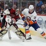 Arizona Coyotes goaltender Antti Raanta (32) and New York Islanders left wing Ross Johnston fight for the puck in the first period during an NHL hockey game, Monday, Feb. 17, 2020, in Glendale, Ariz. (AP Photo/Rick Scuteri)