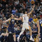Phoenix Suns guard Devin Booker (1) lays up the ball as Utah Jazz guard Joe Ingles (2) defends in the first half during an NBA basketball game Monday, Feb. 24, 2020, in Salt Lake City. (AP Photo/Rick Bowmer)