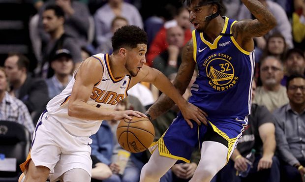 Phoenix Suns guard Devin Booker (1) drives around Golden State Warriors forward Marquese Chriss (32...
