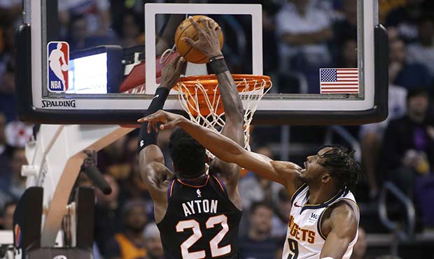 Phoenix Suns center Deandre Ayton (22) dunks against the defense of Denver Nuggets forward Jerami G...