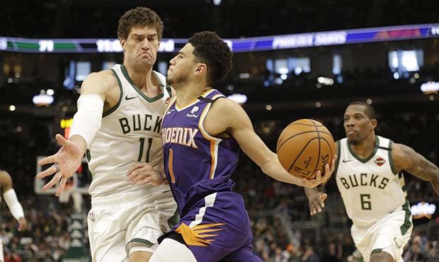 Phoenix Suns' Devin Booker drives against Milwaukee Bucks' Brook Lopez during the second half of an...