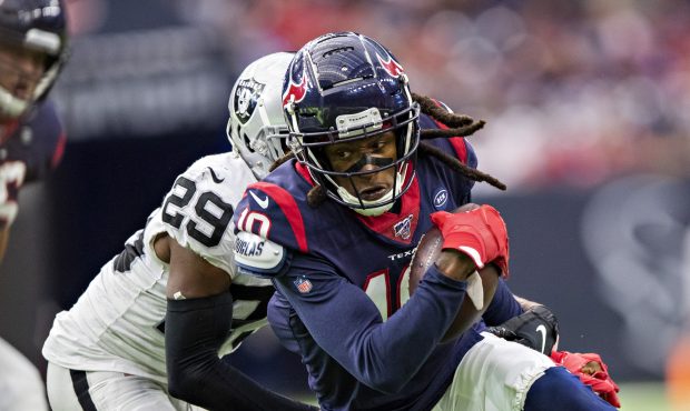 DeAndre Hopkins #10 of the Houston Texans catches a pass and is tackled from behind by Lamarcus Joy...