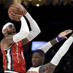 Portland Trail Blazers forward Carmelo Anthony, left, hits a shot over Phoenix Suns forward Cheick Diallo during the first quarter of an NBA basketball game in Portland, Ore., Tuesday, March 10, 2020. (AP Photo/Steve Dykes)