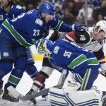 Vancouver Canucks goalie Thatcher Demko (35) makes a save as Alexander Edler (23), of Sweden, checks Arizona Coyotes' Christian Dvorak (18) during the first period of an NHL hockey game Wednesday, March 4, 2020, in Vancouver, British Columbia. (Darryl Dyck/The Canadian Press via AP)