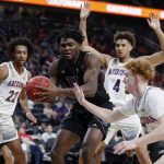 Washington's Isaiah Stewart (33) grabs a rebound over Arizona's Nico Mannion, right, during the first half of an NCAA college basketball game in the first round of the Pac-12 men's tournament Wednesday, March 11, 2020, in Las Vegas. (AP Photo/John Locher)