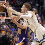 Milwaukee Bucks guard Donte DiVincenzo (0) knocks the ball away from Phoenix Suns guard Ty Jerome (10) as time expires during the first half of an NBA basketball game Sunday, March 8, 2020, in Phoenix. (AP Photo/Matt York)
