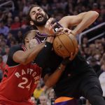 Phoenix Suns guard Ricky Rubio and Toronto Raptors guard Norman Powell (24) get tangled up for a jump ball during the second half of an NBA basketball game Tuesday, March 3, 2020, in Phoenix. The Raptors won 123-114. (AP Photo/Matt York)